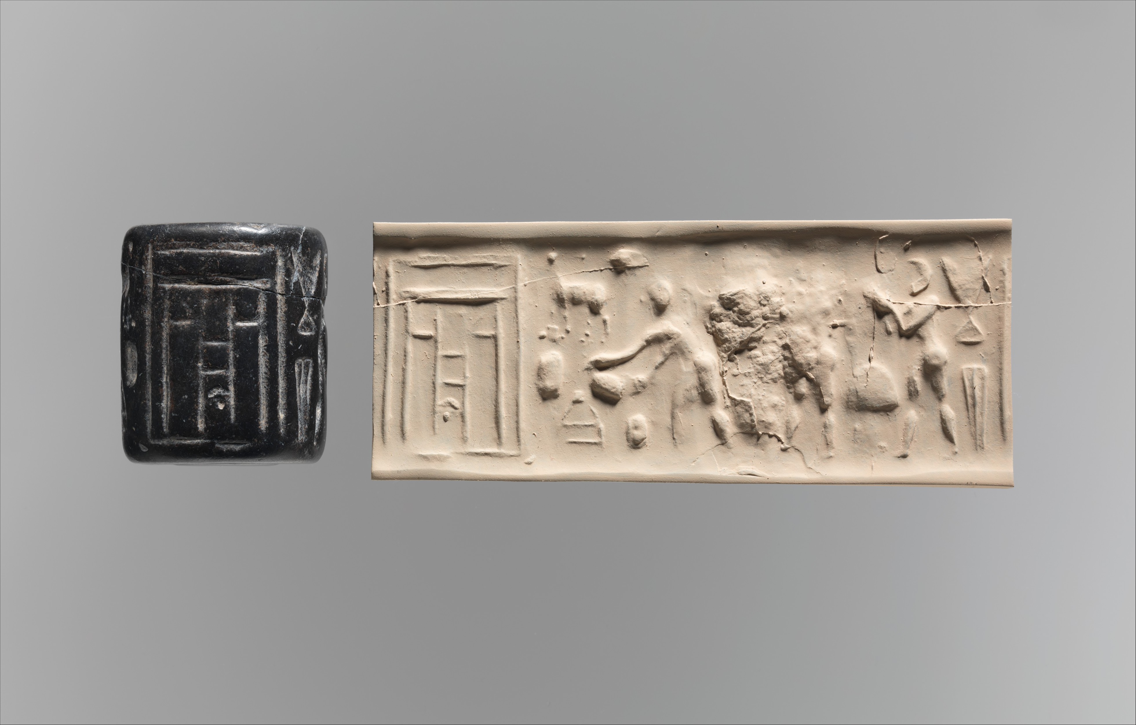 A dark stone cylinder seal beside a modern impression showing figures approaching a building.