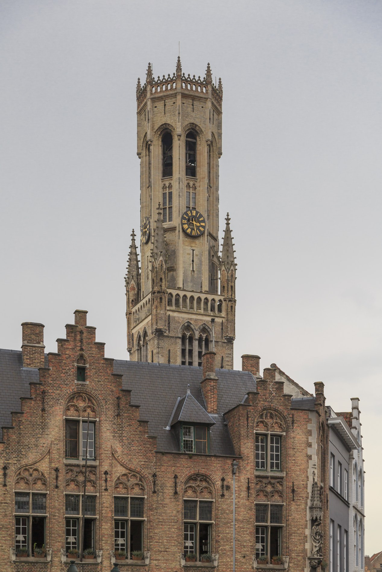 The Bruges belfry rises behind stepped gables, seen from Burg Square.