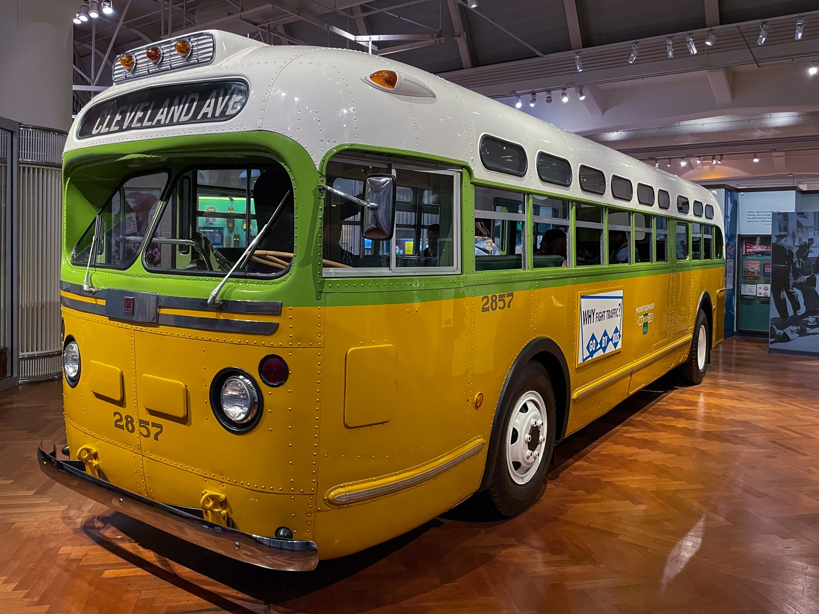 The restored yellow, green and white Cleveland Avenue bus stands inside a museum.
