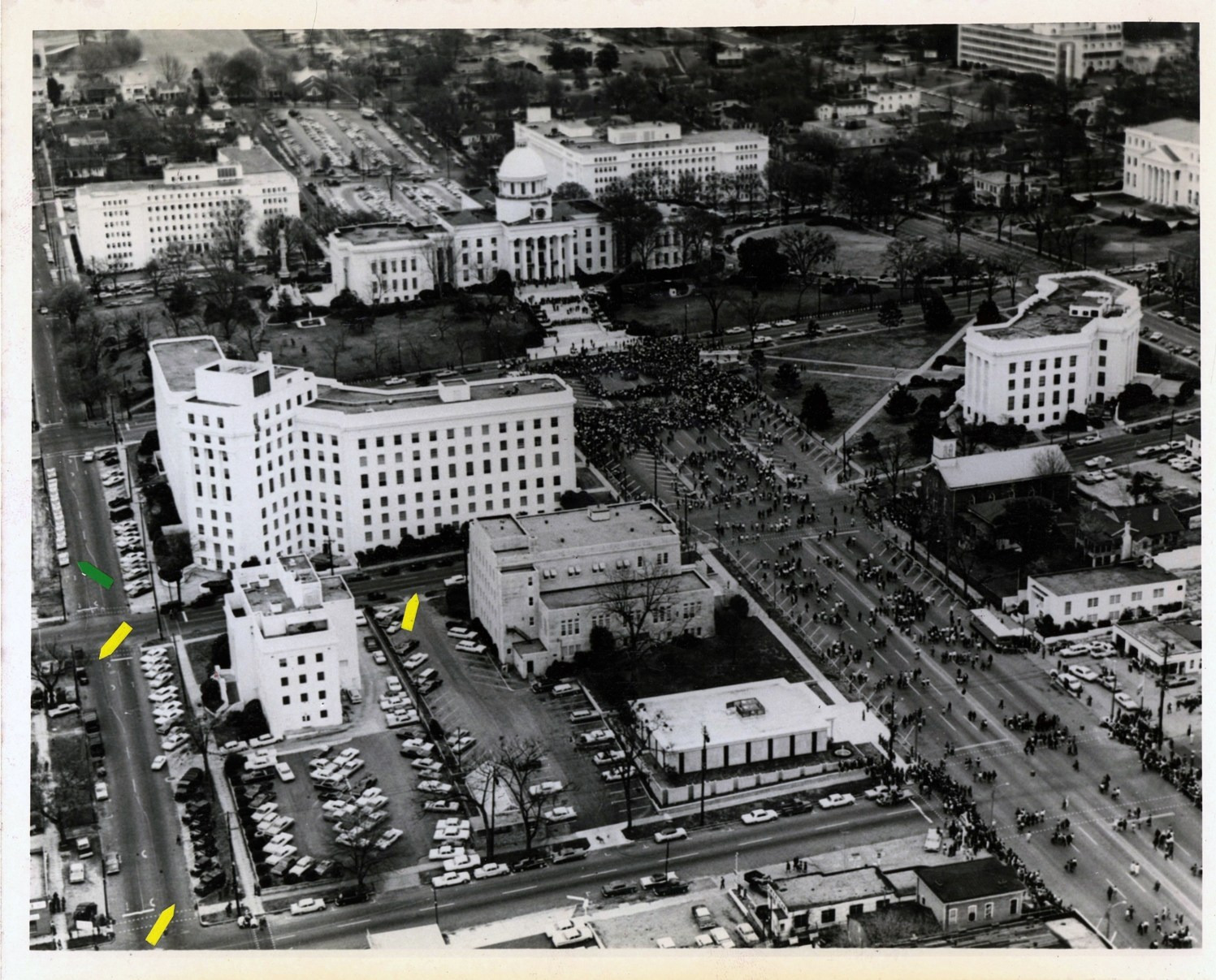 An aerial photograph shows marchers on streets near the Alabama State Capitol, with coloured arrows on the left margin.