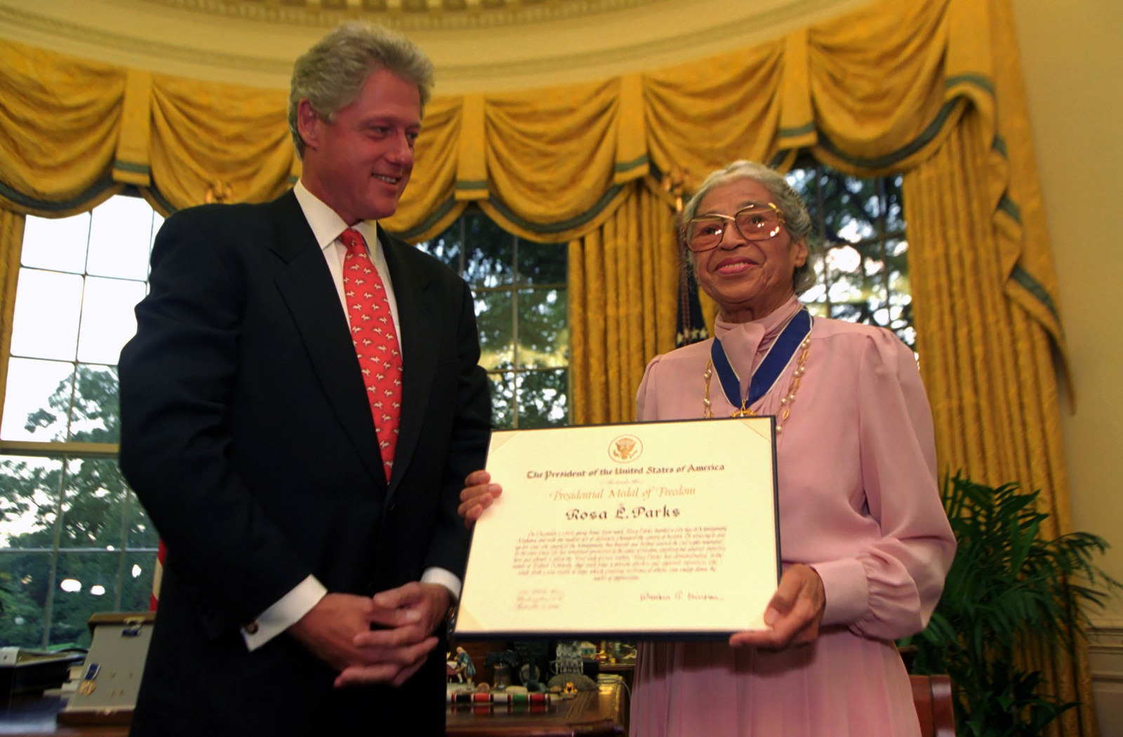 Rosa Parks holds an award certificate beside President Bill Clinton in the Oval Office.